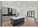 Spacious kitchen with stainless steel appliances, center island, hardwood floors, and a seamless flow to the living area at 18773 Dayspring Pl, Venice, FL 34293