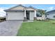 One-story home with white garage door and landscaping at 18876 Daybreak Dr, Venice, FL 34293