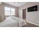 Serene main bedroom with a large window, mounted TV, and ensuite bathroom entrance at 1900 Gulf N Dr # 1, Bradenton Beach, FL 34217