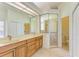 Bathroom with double sinks, large mirror, and walk-in shower at 4817 Shadyview Ct, Sarasota, FL 34232