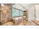 Elegant bathroom with soaking tub, walk-in shower, and glass block window at 495 Mckinley Dr, Sarasota, FL 34236