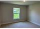 Bedroom featuring neutral carpet, baseboard trim, and a double-paned window overlooking green landscaping at 5018 Wagon Wheel Dr, North Port, FL 34291