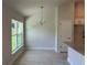 Dining area with natural light, modern chandelier, tile flooring, and view into the kitchen at 5018 Wagon Wheel Dr, North Port, FL 34291