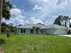 Inviting one-story home showcasing lush green lawn and a well manicured landscape on a cloudy day at 5018 Wagon Wheel Dr, North Port, FL 34291