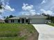 Beautiful single-story home with a well-maintained lawn and a two car garage on a sunny day at 5018 Wagon Wheel Dr, North Port, FL 34291
