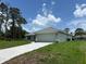 Charming single-story home with a long driveway and attached garage surrounded by lush greenery and beautiful skies at 5018 Wagon Wheel Dr, North Port, FL 34291