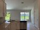 Bright kitchen featuring stainless steel appliances, white cabinetry, granite countertops, and a view through the windows at 5018 Wagon Wheel Dr, North Port, FL 34291