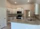 Kitchen with stainless steel appliances, white cabinets, granite countertops, and an island with a sink at 5018 Wagon Wheel Dr, North Port, FL 34291