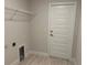 Laundry room featuring a wire rack shelf, tile flooring, and a modern door at 5018 Wagon Wheel Dr, North Port, FL 34291