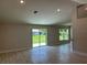 Bright living room with wood-look tile flooring and a sliding glass door that provides plenty of natural light at 5018 Wagon Wheel Dr, North Port, FL 34291
