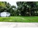 Large backyard with lush landscaping and a storage shed at 603 Padua Ct, Nokomis, FL 34275