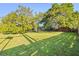 Large, grassy backyard with mature trees and wood fence at 7607 9Th Avenue Nw Dr, Bradenton, FL 34209