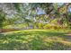 Expansive backyard featuring lush green grass, mature shade trees, and wood fencing at 7607 9Th Avenue Nw Dr, Bradenton, FL 34209