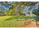 Beautiful backyard showcasing mature shade trees, green grass, and wood fencing at 7607 9Th Avenue Nw Dr, Bradenton, FL 34209