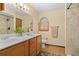 Bathroom featuring double sinks, wood cabinets, a neutral paint scheme and tile shower at 7607 9Th Avenue Nw Dr, Bradenton, FL 34209