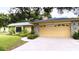 Exterior view of the house with a two-car garage and green lawn at 7607 9Th Avenue Nw Dr, Bradenton, FL 34209