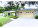 Charming home featuring a stone facade, mature trees, and a well-manicured lawn at 7607 9Th Avenue Nw Dr, Bradenton, FL 34209