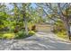 Charming home featuring a stone facade, mature trees, and a well-manicured lawn at 7607 9Th Avenue Nw Dr, Bradenton, FL 34209