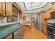 Bright kitchen with wood cabinets, stainless steel appliances, green countertops, and a view of the living room at 7607 9Th Avenue Nw Dr, Bradenton, FL 34209