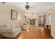 Inviting living room featuring a stone fireplace, comfortable seating, wood floors, and a ceiling fan at 7607 9Th Avenue Nw Dr, Bradenton, FL 34209