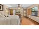 Main bedroom with hardwood floors, decorative ceiling fan, and ensuite bath with sliding glass doors at 7607 9Th Avenue Nw Dr, Bradenton, FL 34209
