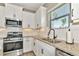 White shaker cabinets, granite countertops, and stainless steel sink in this kitchen at 11624 Okaloosa Dr, Venice, FL 34293