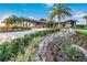 Community clubhouse with stonework and landscaping at 7390 Divot Loop, Lakewood Ranch, FL 34202