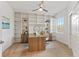 Spacious home office with built-in shelving and a large desk at 7390 Divot Loop, Lakewood Ranch, FL 34202