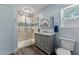 Updated bathroom with glass shower, gray vanity, and light blue walls at 1332 3Rd W Ave, Bradenton, FL 34205