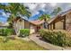 Single-Gathering home with a red door and palm trees at 6935 Arbor Oaks Cir, Bradenton, FL 34209