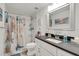 Clean bathroom with a shower/tub combo, vanity with dark countertop, and beach-themed decor at 303 48Th W St, Bradenton, FL 34209