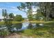 Charming pond with fountain, surrounded by lush greenery and trees at 3653 Bonaventure Ct, Sarasota, FL 34243
