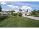 Landscaped yard with two-car garage and home exterior at 3653 Bonaventure Ct, Sarasota, FL 34243