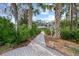 Paved walkway to community area, bordered by palm trees and foliage at 3653 Bonaventure Ct, Sarasota, FL 34243