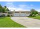 Two-car garage with a spacious driveway and lush landscaping at 3072 Meyer Dr, Sarasota, FL 34239