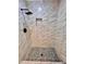 Modern shower with marble-look tile and pebble floor at 1111 Longfellow Rd # 1111, Sarasota, FL 34243
