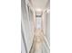 Long hallway with tile floors and multiple doors to bedrooms and other rooms at 1111 Longfellow Rd # 1111, Sarasota, FL 34243