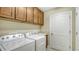 Bright laundry room, washer, dryer, and ample cabinetry at 7546 Divot Loop, Lakewood Ranch, FL 34202