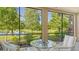 Serene screened patio with glass table and chairs, pond view at 7546 Divot Loop, Lakewood Ranch, FL 34202