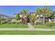 Two-story tan house with palm trees and manicured lawn at 7546 Divot Loop, Lakewood Ranch, FL 34202