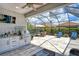 Outdoor kitchen and screened patio with grill and seating area at 8744 Bellussi Dr, Sarasota, FL 34238