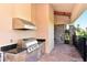 Outdoor kitchen with stainless steel grill and granite countertops at 8744 Bellussi Dr, Sarasota, FL 34238