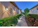 Evening view of a brick pathway, manicured hedges, and landscape lighting at 8744 Bellussi Dr, Sarasota, FL 34238