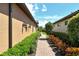 Brick pathway bordered by lush greenery leads through a charming side yard at 8744 Bellussi Dr, Sarasota, FL 34238