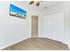 Comfortable bedroom with wood-look floors, a ceiling fan, and a double door closet at 12734 Rainwashed Loop, Parrish, FL 34219