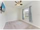 Bright bedroom with ceiling fan, wall-mounted TV, and grey carpeting at 12734 Rainwashed Loop, Parrish, FL 34219