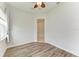 Bright bedroom with wood-look floors, ceiling fan, and access to another room at 12734 Rainwashed Loop, Parrish, FL 34219