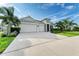 Modern home exterior with three-car garage and lush landscaping at 12734 Rainwashed Loop, Parrish, FL 34219