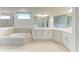 Elegant bathroom featuring a corner vanity, a large soaking tub, and a shower at 12734 Rainwashed Loop, Parrish, FL 34219