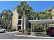 Condo building exterior with palm trees and covered parking at 7005 River Hammock Dr # 404, Bradenton, FL 34212